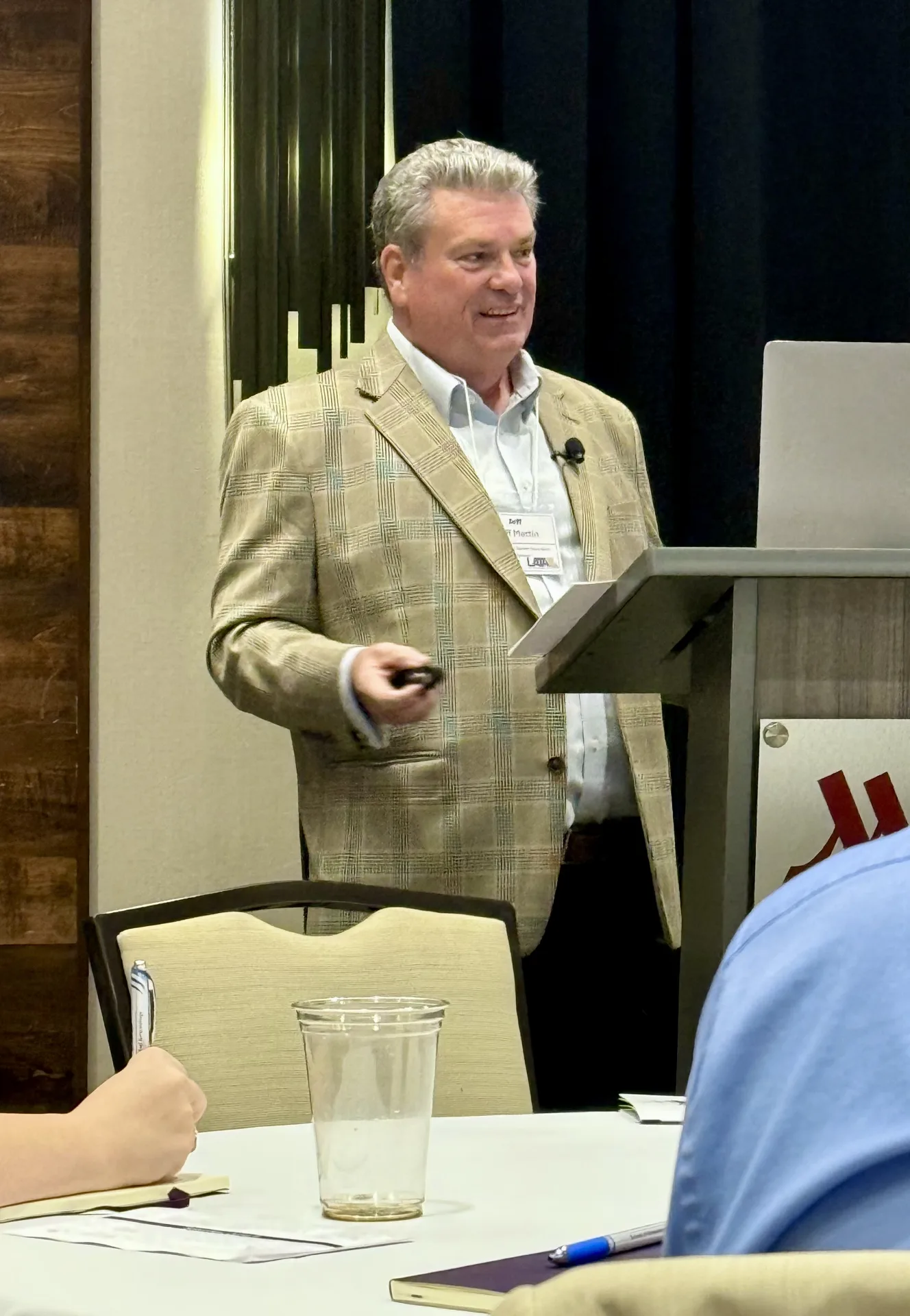 Business coach Jeff Martin speaking to a room of business owners from a lectern